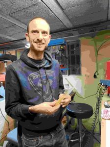 Stagiaire souriant avec le couteau qu’il a fabriqué