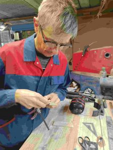 Stagiaire utilisant une machine artisanale pour façonner son couteau