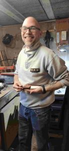 Stagiaire heureux présentant son couteau artisanal terminé