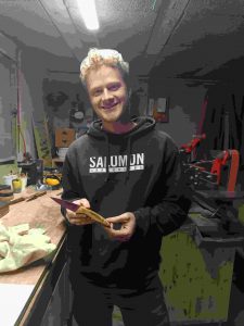 Stagiaire souriant avec le couteau qu’il a fabriqué