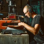 Coutelier artisanal en Savoie découpant des plaquettes de bois pour le manche d’un couteau de cuisine fait main