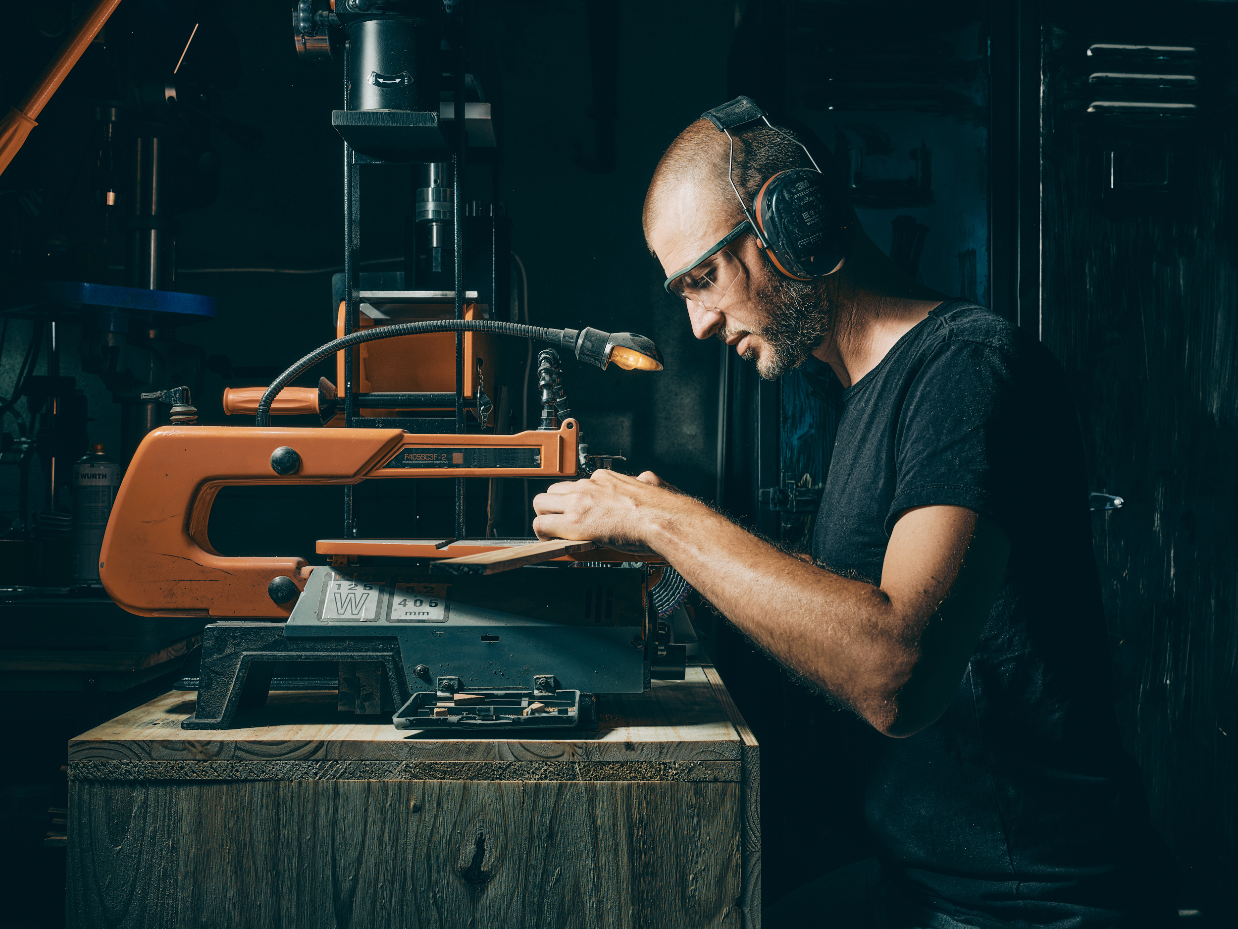 Artisan coutelier Jean Dufour dans son atelier de coutellerie à Chambéry en Savoie préparant les plaquettes en bois d’un couteau de cuisine artisanal.