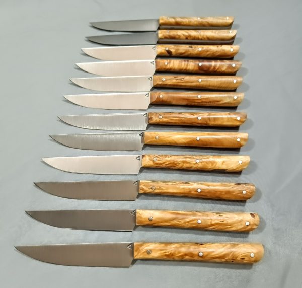 Service de douze couteaux artisanaux modèle n°2 pour la table avec manches en loupe de marronnier stabilisé, fabrication artisanale à la Coutellerie Bermudes près de Chambéry en Savoie.