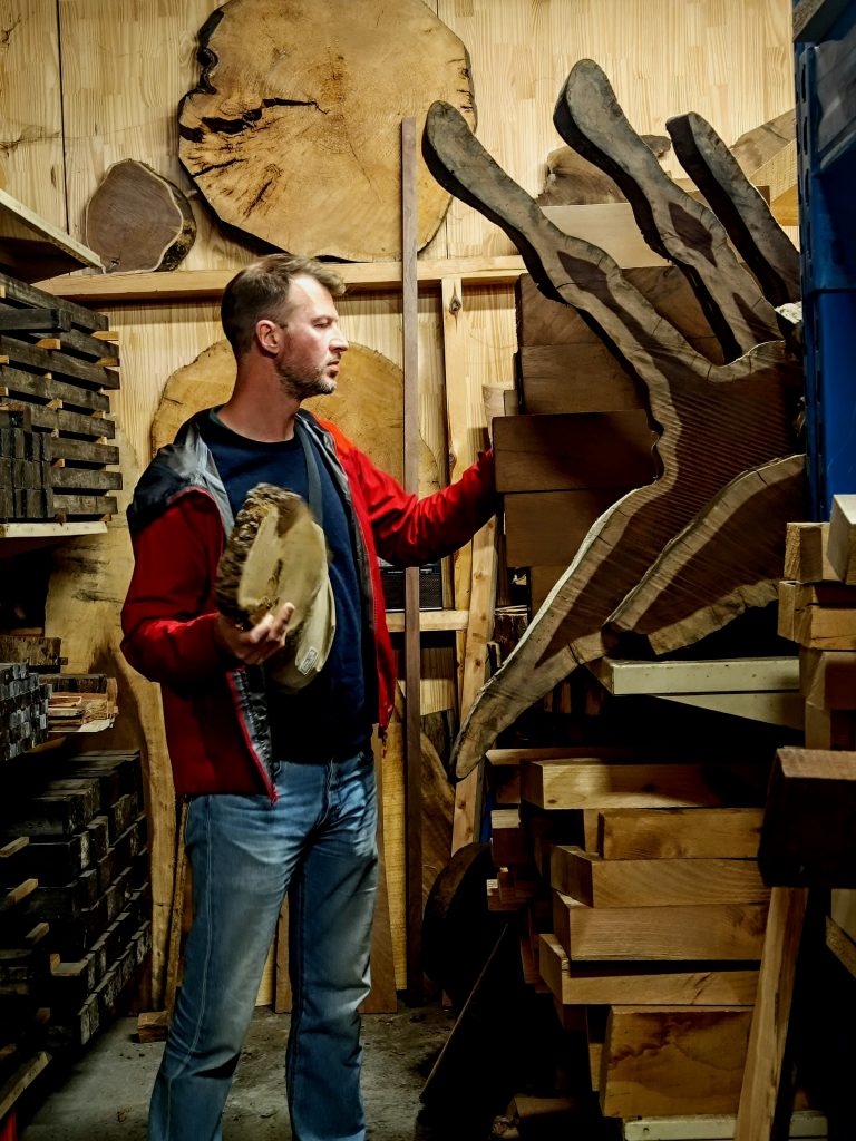 Artisan coutelier sélectionnant du bois pour fabriquer des manches de couteaux artisanaux à la Coutellerie Bermudes près de Chambéry en Savoie.