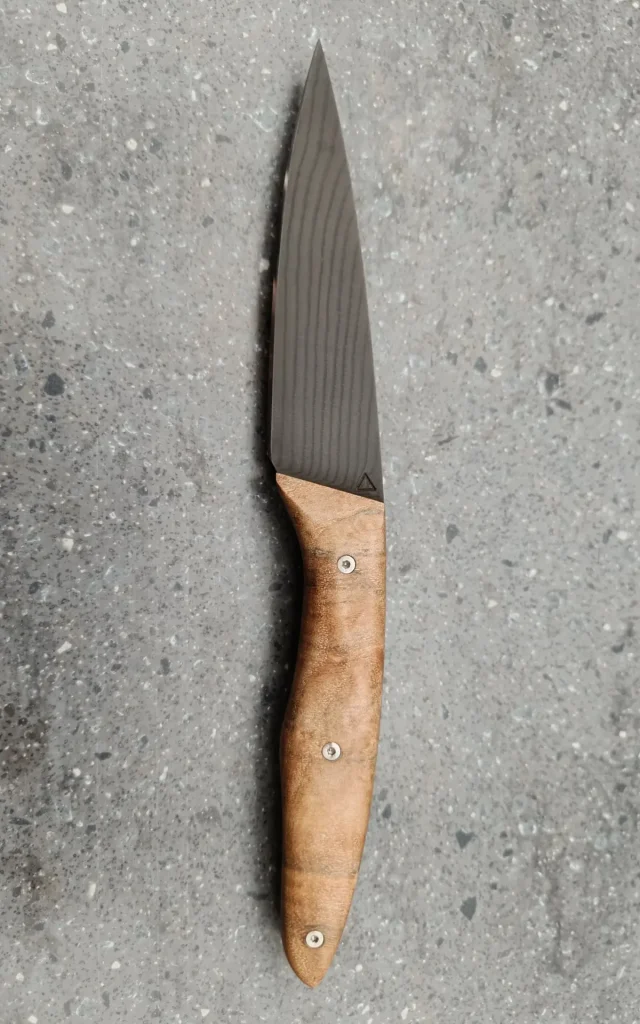 Couteau de cuisine artisanal avec lame damas sombre et manche en bois, vue recto