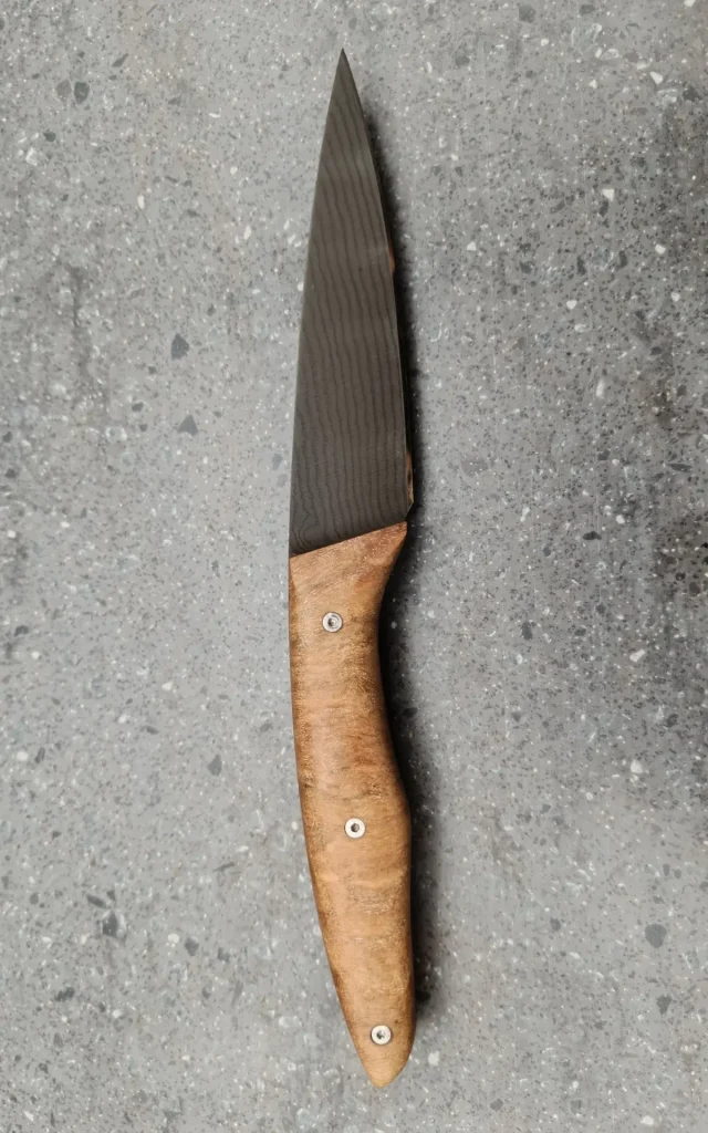 Couteau de cuisine artisanal avec lame damas sombre et manche en bois, vue verso