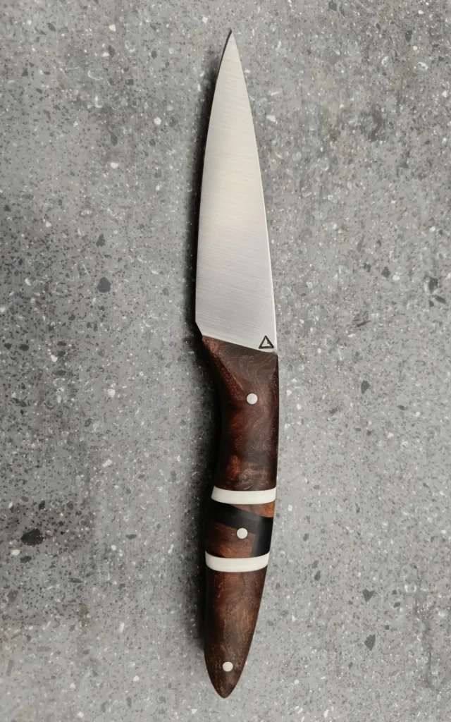Couteau de cuisine artisanal avec manche en bois brun et intercalaires noirs et blancs, vue recto